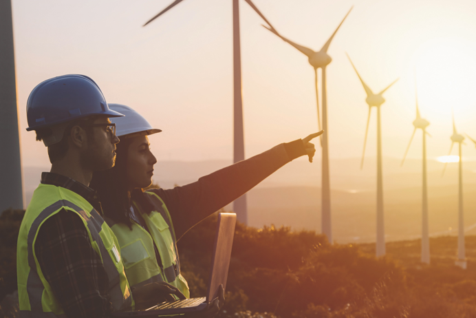 Two people next to windturbines 1384x923