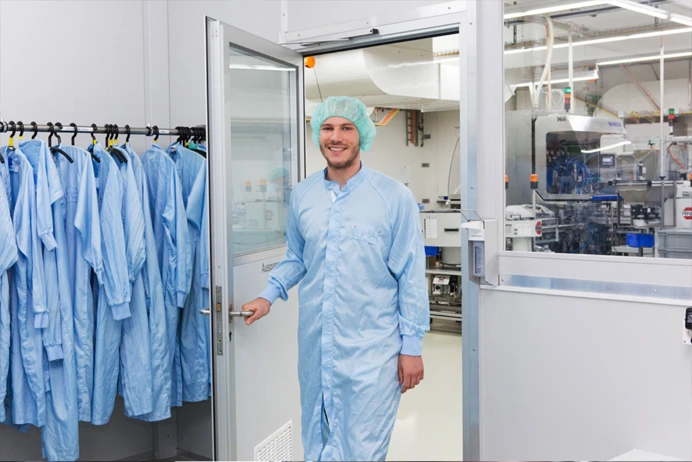 Man in a blue safe suit opening a door