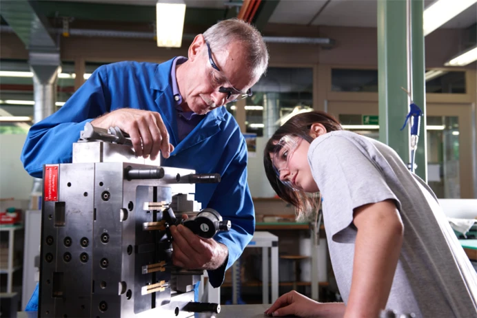 Image of a man and a boy next to a machine